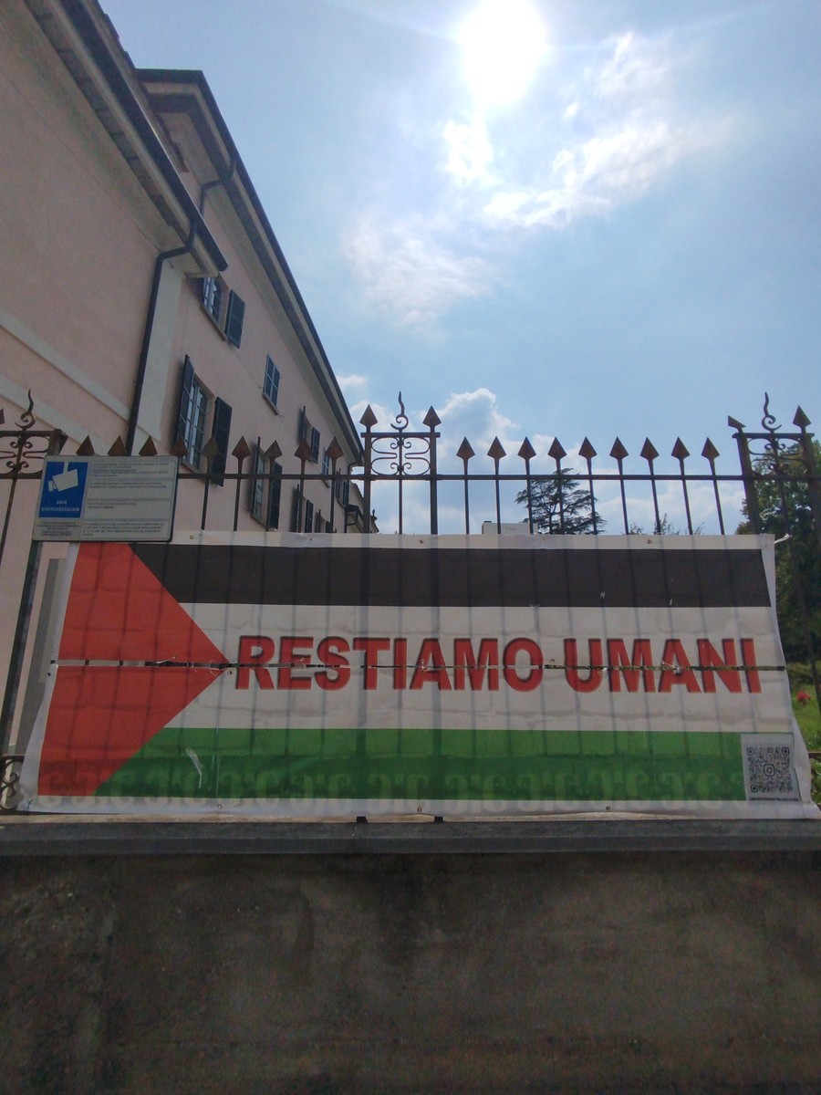Restiamo umani, sempre: lo striscione strappato è tornato al suo posto in via Sacco