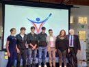 I ragazzi dell'Istituto Falcone con alle spalle il logo da loro disegnato