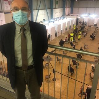 Il dottor Marino Dell'Acqua al centro vaccinale. Nella foto sotto con alcuni dei medici che si sono resi disponibili a MalpensaFiere