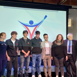 I ragazzi dell'Istituto Falcone con alle spalle il logo da loro disegnato