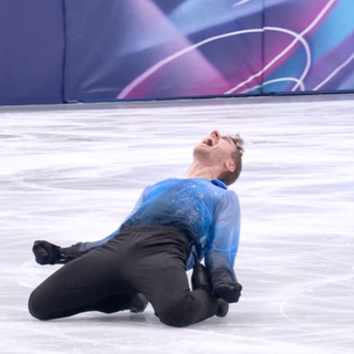 Matteo Rizzo sdraiato sul ghiaccio del Forum dopo il singolo di stasera che è valso il bronzo all'Italia nel pattinaggio di figura a squadre