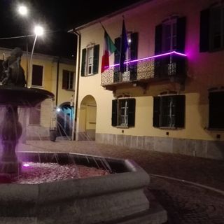 La fontana della piazza e il palazzo comunale di Gavirate colorati di rosa
