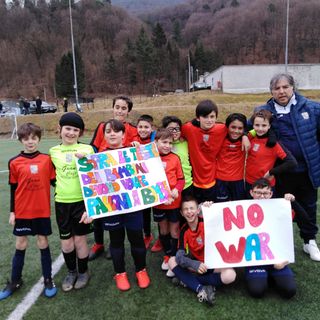La squadra dei pulcini misti dell'Olona Calcio con gli striscioni a favore della pace