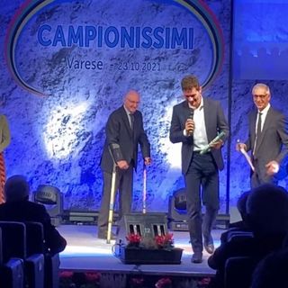 Uno dei momenti più intensi dell'edizione 2021 di Campionissimi: Filippo Tortu, seguito dallo sguardo affettuoso di Livio Berruti (sul palco), consegna il testimone dell'ultima frazione della staffetta d'oro olimpica ad Alfredo Ambrosetti