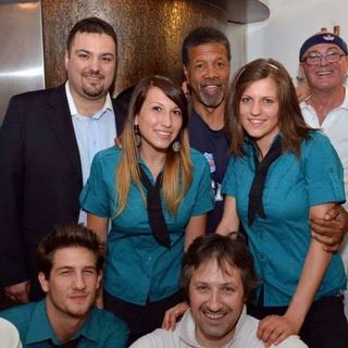 Dario De Gasperin, secondo da destra in piedi, tra la figlia Roberta, Charlie Yelverton, il figlio Davide e lo staff della pizzeria La Speranza dove ha lavorato dal 1986 al 2017