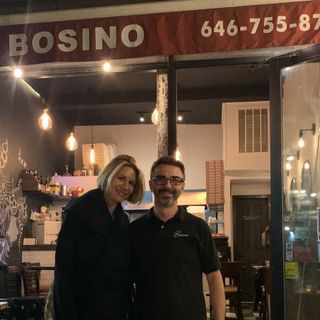 Davide Pupillo davanti al suo ristorante insieme a una cliente