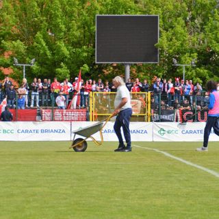 La surreale immagine di un addetto della Folgore Caratese con carriola in mezzo al campo prima della finale playout, mentre erano in corso gli scavi sulla linea di porta per alzare la traversa