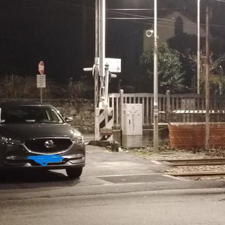L'auto ferma tra i binari del passaggio a livello della stazione di Cocquio (foto tratta da Sei di Cocquio se)