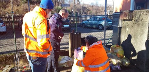 I controlli sui sacchi della spazzatura abbandonati in una foto tratta dalla pagina Facebook Polis