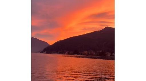 L'alba "rossa" riflessa sul lago a Porto Ceresio
