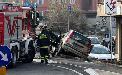 Auto esce di strada e finisce in bilico su un muretto