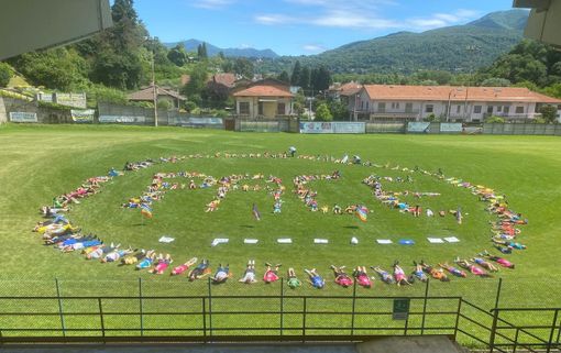 I bambini dell'oratorio di Besozzo hanno formato la parola Pace al centro del campo dello stadio Marvelli
