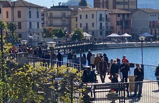 Visitatori a Porto Ceresio sulla passerella sul lungolago