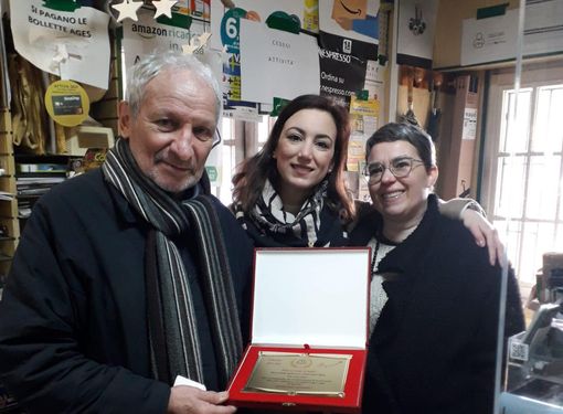 Edmondo "Momo" Secchi premiato dall'associazione commercianti Besozziamo nella sua edicola (foto dalla pagina Facebook Besozziamo)