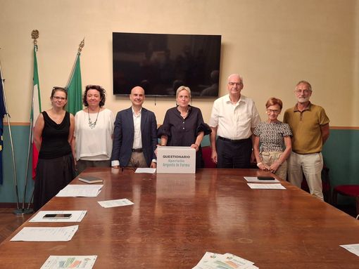 La presentazione del questionario, in Comune. Fra le mani dell'assessore Paola Reguzzoni, uno dei contenitori per la raccolta dei plichi compilati