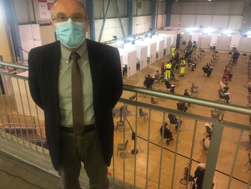 Il dottor Marino Dell'Acqua al centro vaccinale. Nella foto sotto con alcuni dei medici che si sono resi disponibili a MalpensaFiere