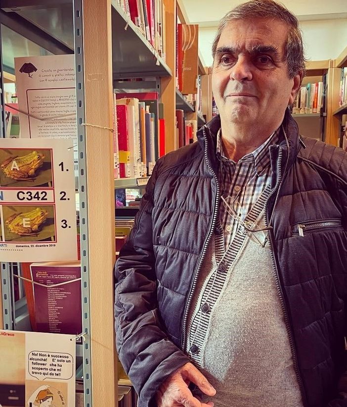 Il signor Angelo Greco con alcuni dei suoi rebus collocati nelle sale della biblioteca di Cavaria con Premezzo