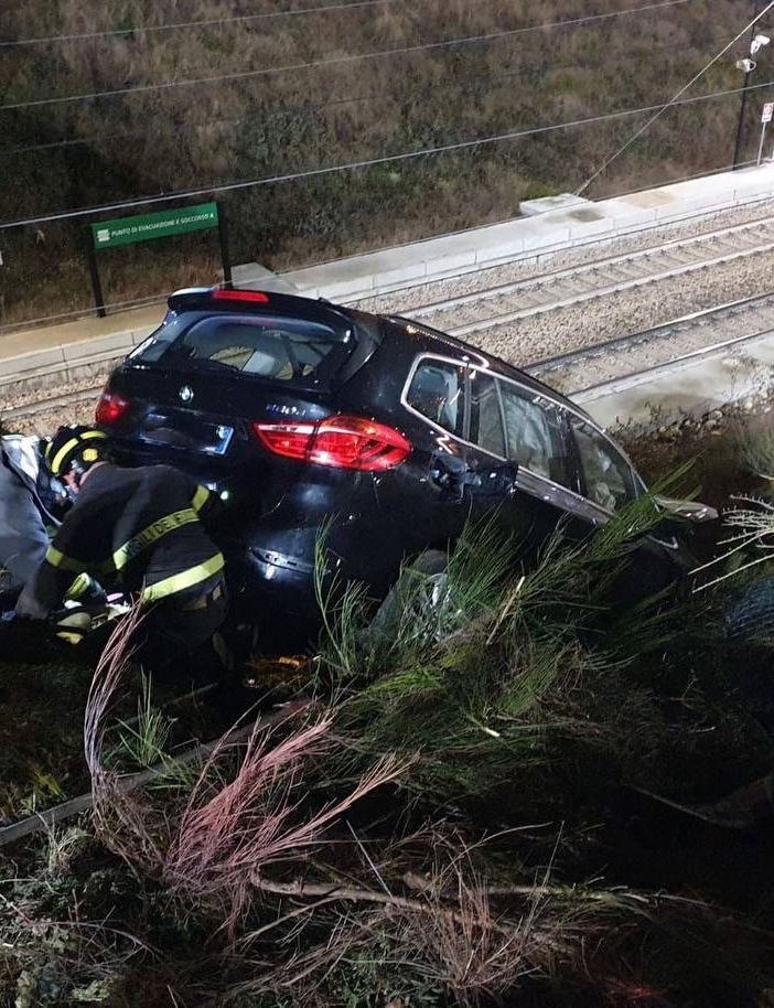 FOTO. Perde il controllo dell'auto e finisce in bilico sulla ferrovia: per recuperarlo servono i vigili del fuoco
