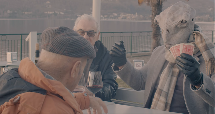 La partita a carte tra cittadini di Ranco e un alieno in riva al lago Maggiore (foto tratta dal video della Pro Loco) La partita a carte tra cittadini di Ranco e un alieno in riva al lago Maggiore (foto tratta dal video della Pro Loco)