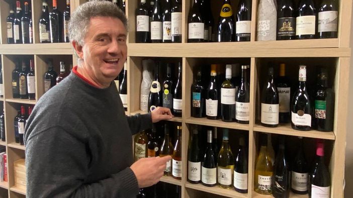 L'inconfondibile sorriso di Francesco Mangia tra le sue bottiglie del locale Luppoli e Uva di via Sanvito 111 a Varese
