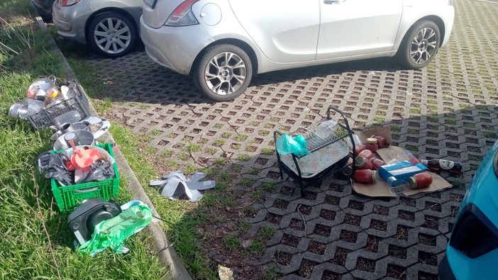 Barattoli, piatti e bottiglie abbandonati in un parcheggio di viale Europa
