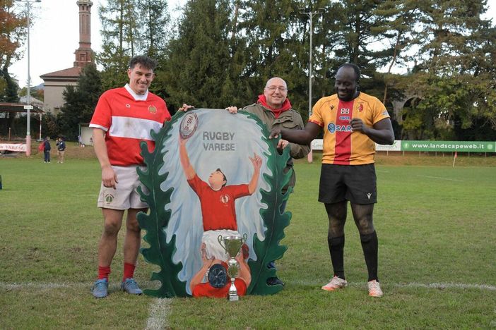 Il presidente Barbieri, al centro, con Andrea Sacchetti e Nuhu Cibsa davanti al quadro in ricordo di Lucio