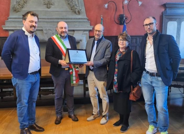 Il sindaco Bellaria consegna la targa ricordo ai coniugi Voltolini (foto dalla pagina Facebook del Comune)
