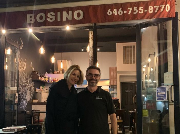 Davide Pupillo davanti al suo ristorante insieme a una cliente