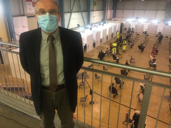 Il dottor Marino Dell'Acqua al centro vaccinale. Nella foto sotto con alcuni dei medici che si sono resi disponibili a MalpensaFiere