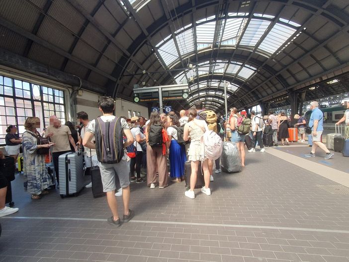 Viaggiatori chiedono informazioni agli addetti a Milano Centrale Viaggiatori chiedono informazioni agli addetti a Milano Centrale