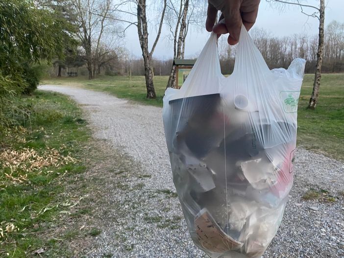 Il sacchetto di rifiuti raccolti dal sindaco di Angera sul sentiero di un parco Il sacchetto di rifiuti raccolti dal sindaco di Angera sul sentiero di un parco