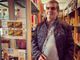 Il signor Angelo Greco con alcuni dei suoi rebus collocati nelle sale della biblioteca di Cavaria con Premezzo