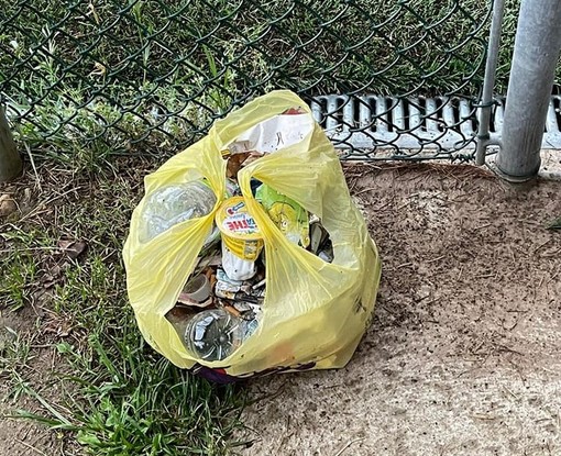 Un sacco dell'immondizia abbandonato al campo Bergora di Buguggiate (foto dalla pagina Facebook del Comune)