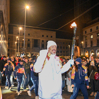 Un sorridente ed emozionato Andrea Meneghin, dopo aver ricevuto la fiaccola olimpica dall'eroe dell'hockey Jim Corsi e prima di cederla a Daniela Colonna Preti, presidentessa della Polha, viene accolto da un muro di folla in piazza Monte Grappa. E il cuore della città batte così forte quasi da uscire dal petto (foto Galbiati)