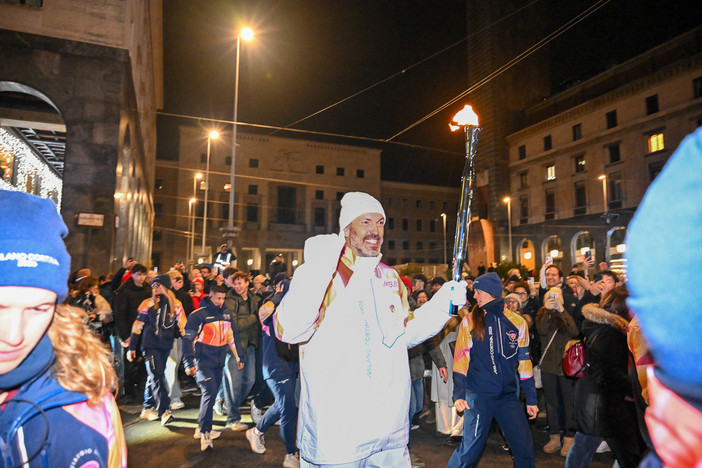 Un sorridente ed emozionato Andrea Meneghin, dopo aver ricevuto la fiaccola olimpica dall'eroe dell'hockey Jim Corsi e prima di cederla a Daniela Colonna Preti, presidentessa della Polha, viene accolto da un muro di folla in piazza Monte Grappa. E il cuore della città batte così forte quasi da uscire dal petto (foto Galbiati)