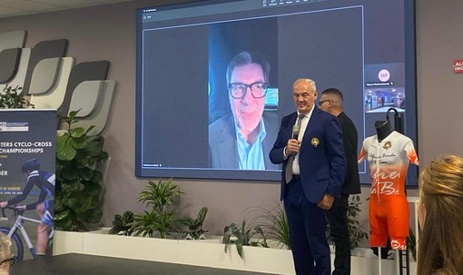 Renzo Oldani, presidente della Società Ciclistica Binda, e dietro il ministro dell'Economia Giancarlo Giorgetti, collegato in video
