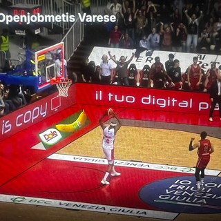 Immagine simbolo del finale a Trieste: Moore intento a scagliare il pallone a terra con rabbia dopo aver fallito il canestro della vittoria, sullo sfondo della panchina di Trieste che esulta