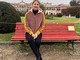 Ivana Perusin seduta da sola sulla panchina rossa dei Giardini: quando un gesto batte la violenza sulle donne più delle parole